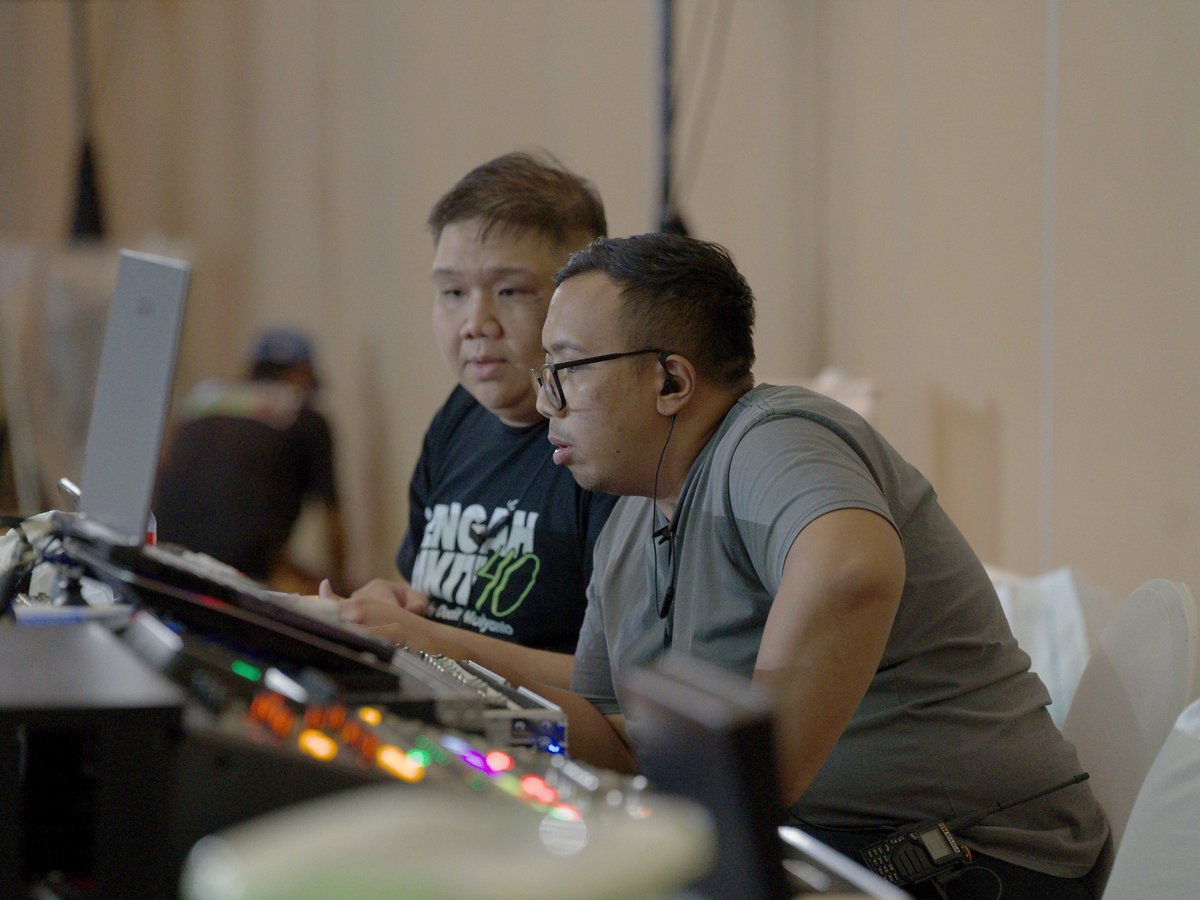 Operator memantau perangkat switching di area kontrol produksi